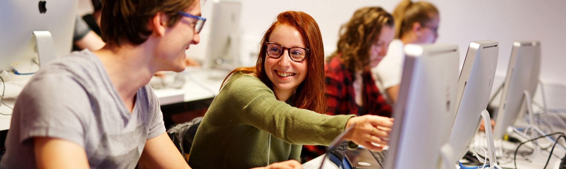 personnes qui travaillent et discutent dans une salle informatique