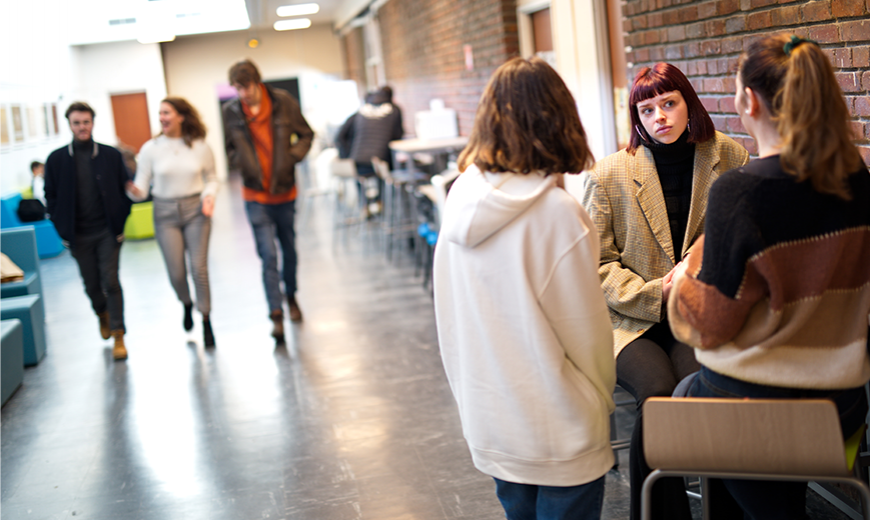 personnes qui discutent dans un des couloirs de l'Université