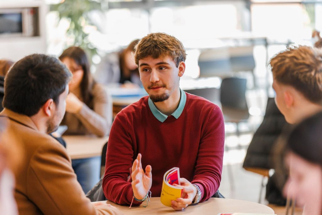 Groupe d'étudiants qui discutent autour d'une table de l'université SHS